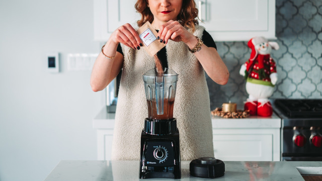 woman mixing a supplement into a blender